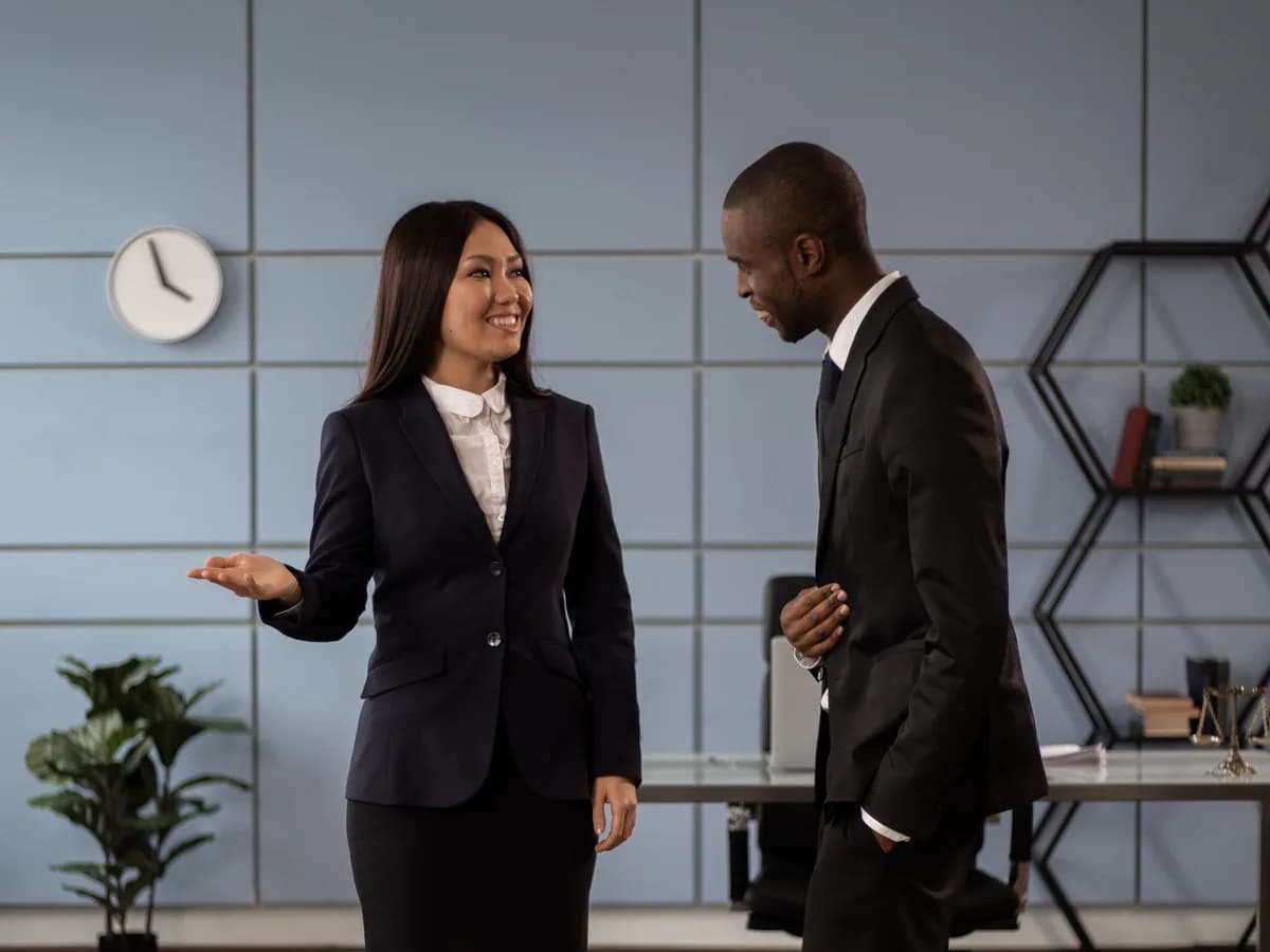Two professionals discussing cover in an office